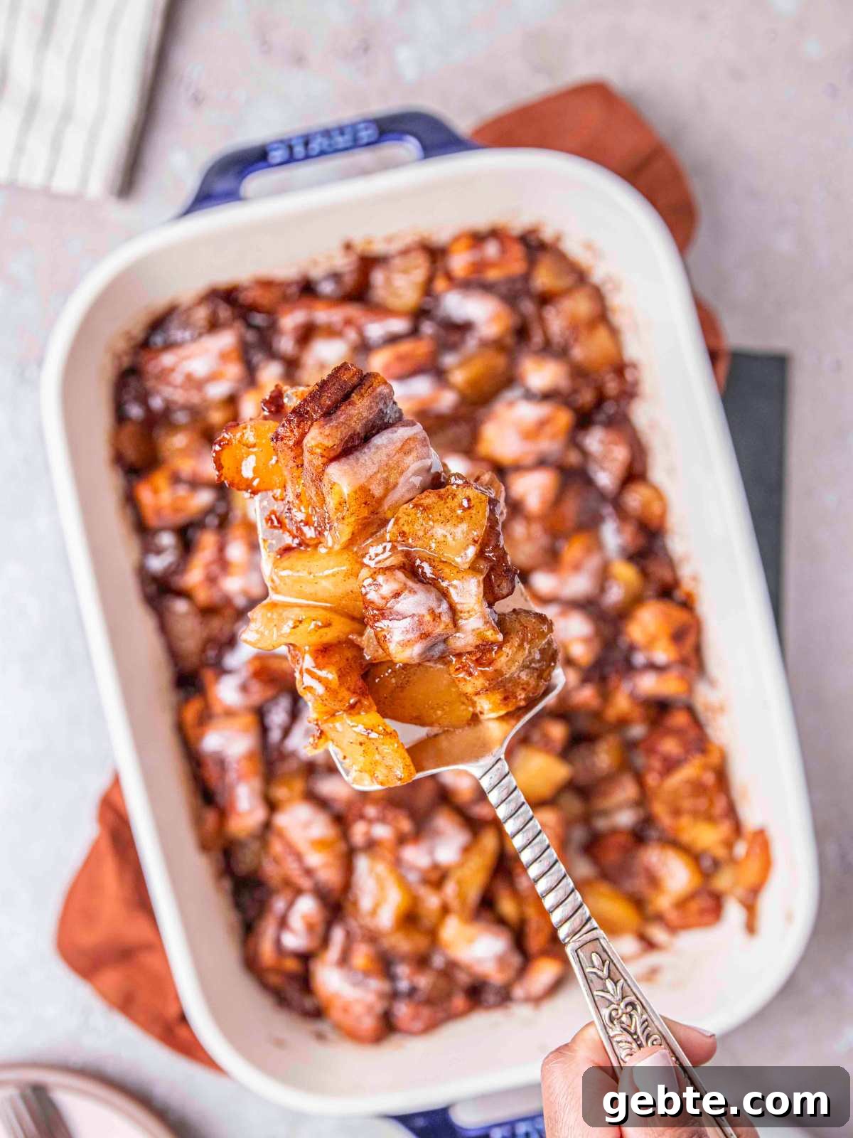 A slice of the cinnamon roll with apple pie filling.