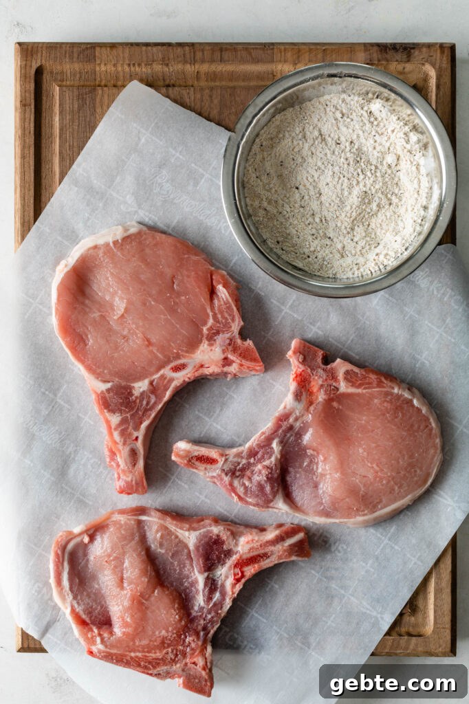 three pork chops and a bowl of seasoned flour